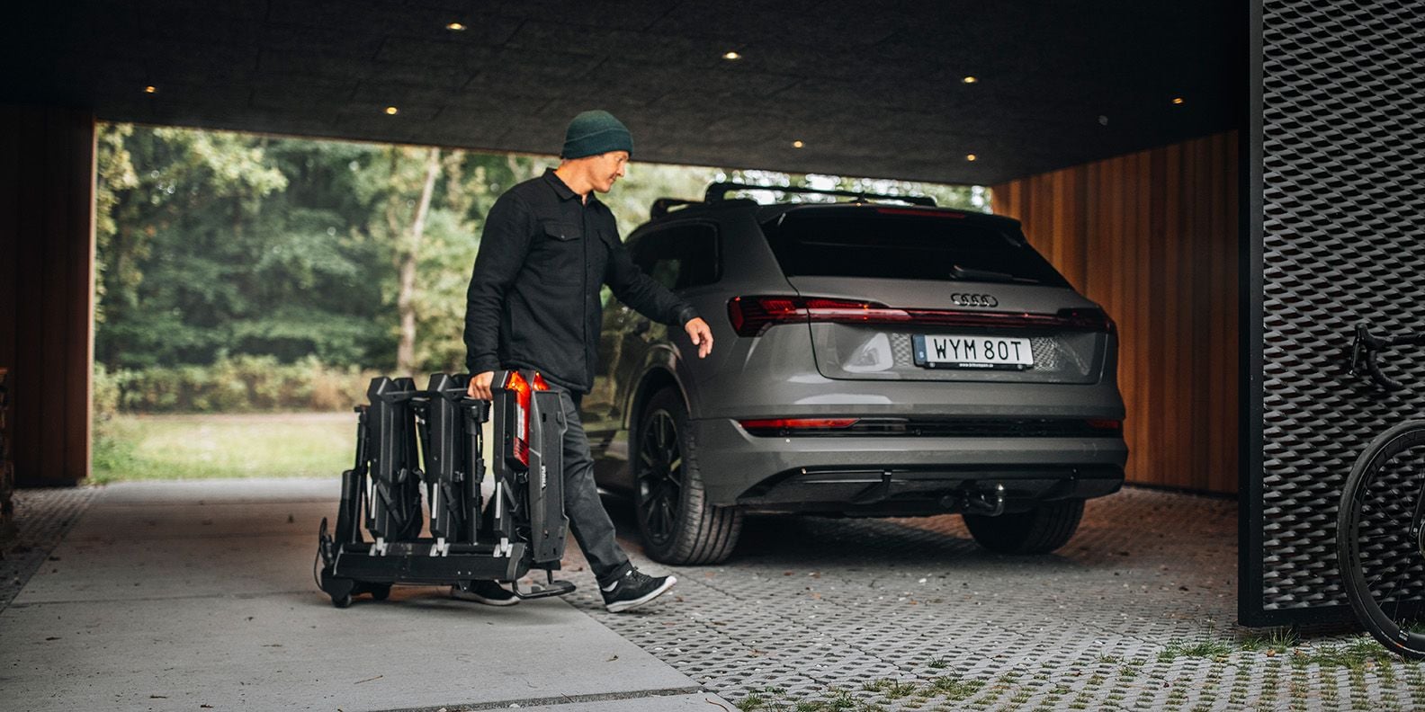 En man bär Thule Epos cykelhållare mot bakänden på bilen