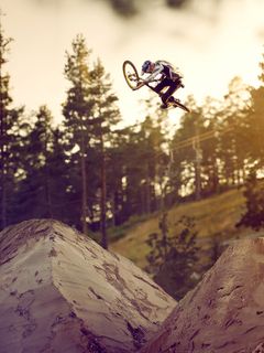 Martin Söderström does a bike trick in the air at a bike park with dirt jumps.