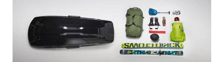 A flatlay of the Thule Vector L roof box featuring all the ski gear you can fit inside.