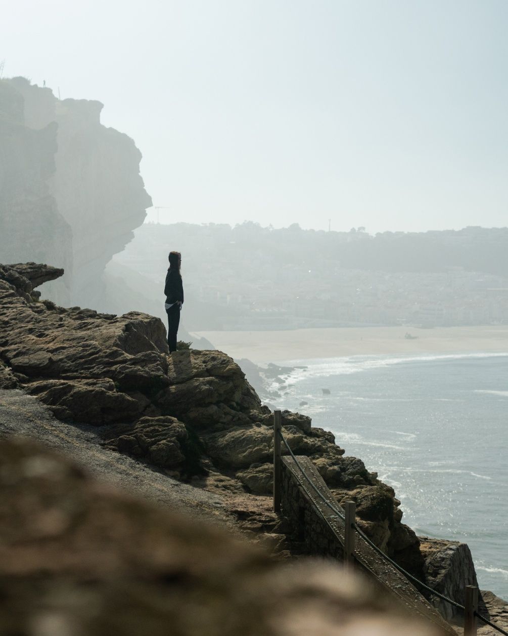 Maria Kuzma stands on the edge of a cliff while looking out into the sea.