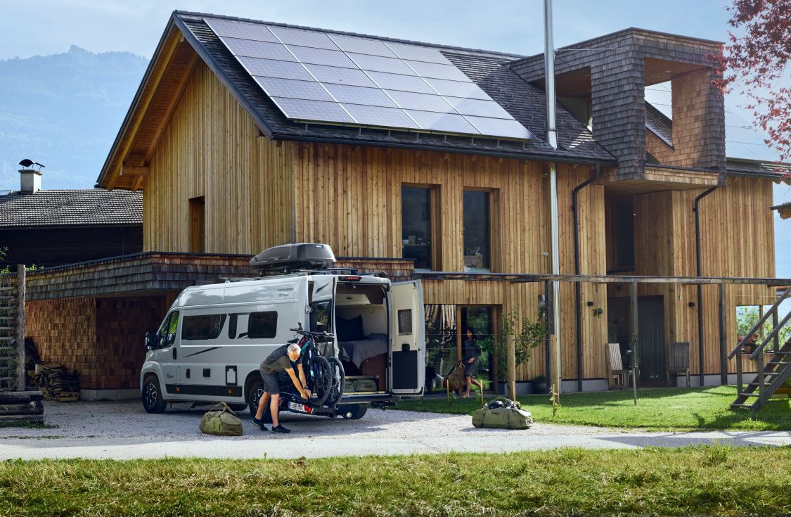 한 남자가 Thule 장비를 밴에 싣고 RV 여행을 준비하고 있습니다.