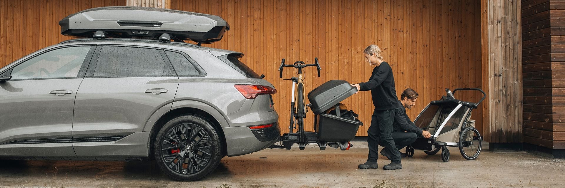 Una donna sta caricando l'attrezzatura su un trasportatore cargo montato su un carro di traino.