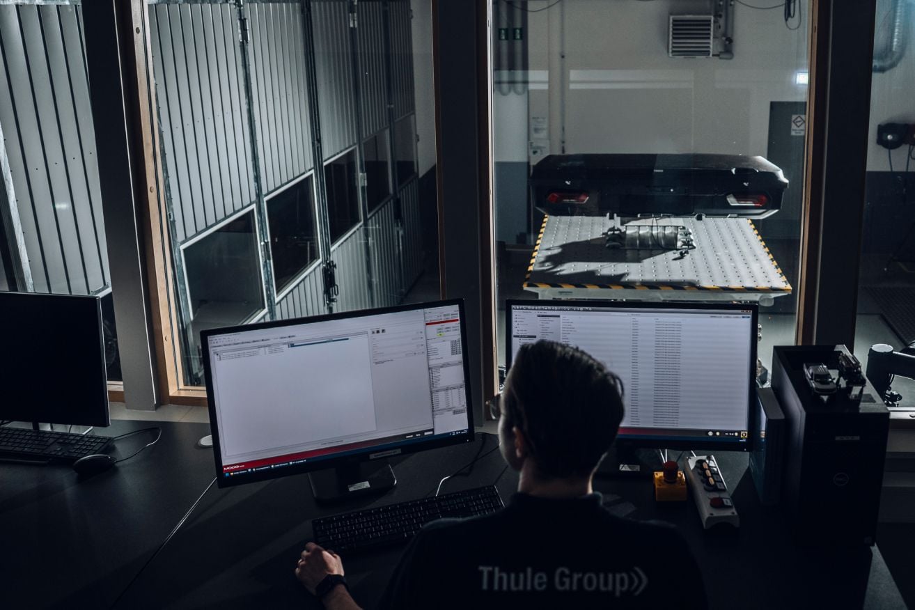 Engineers monitoring cargo carrier testing and performance data in the Thule Test Center.