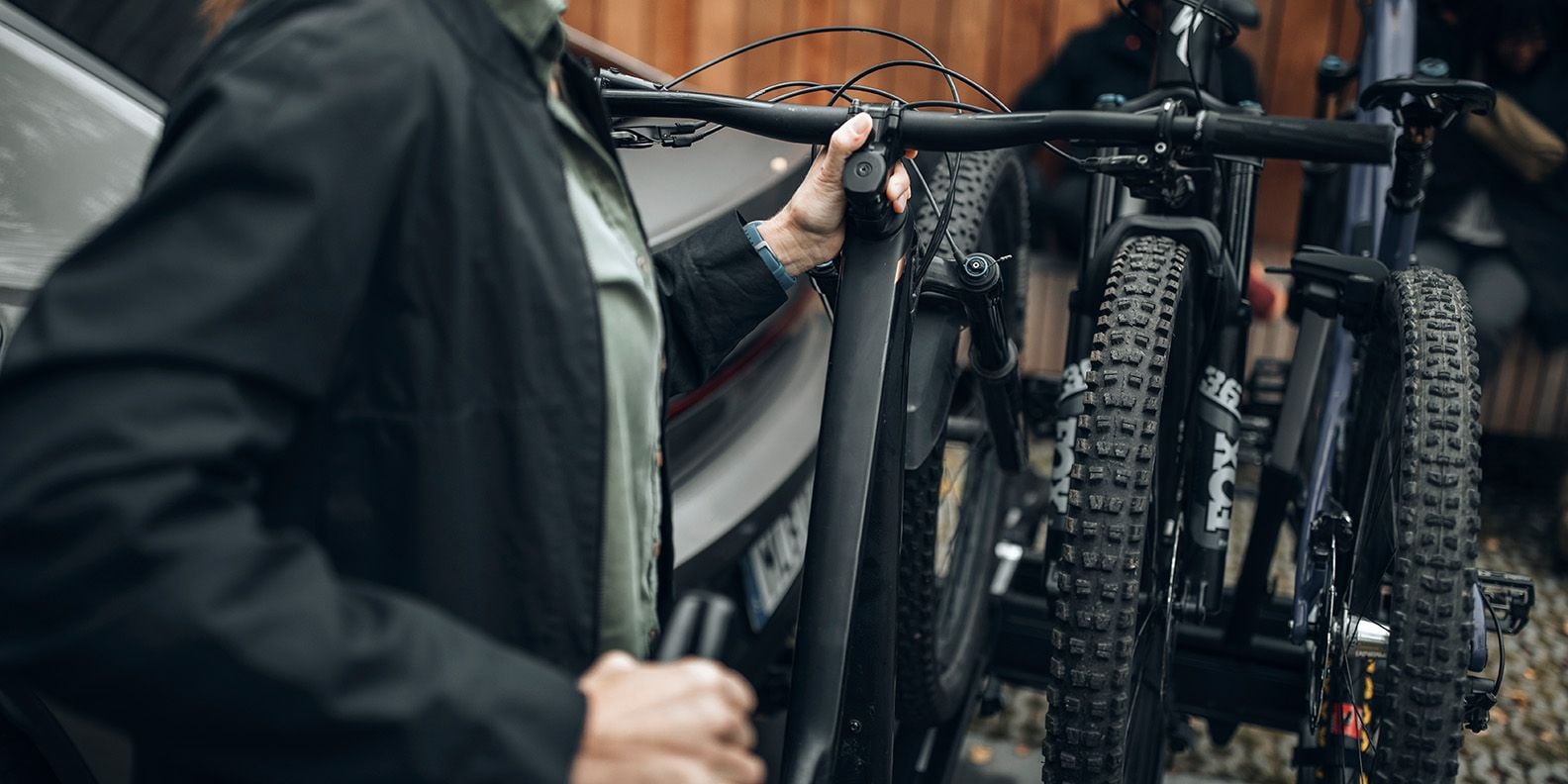 Primo piano di 2 bici montate su Thule Epos e una terza bici che viene aggiunta