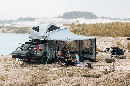 Auto con tenda Thule sul tetto parcheggiata nella natura