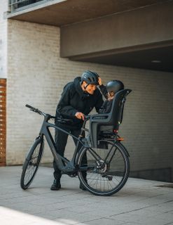 Persona que va en una bici de carga con dos sillas maxi infantiles Thule Yepp Nexxt 2.