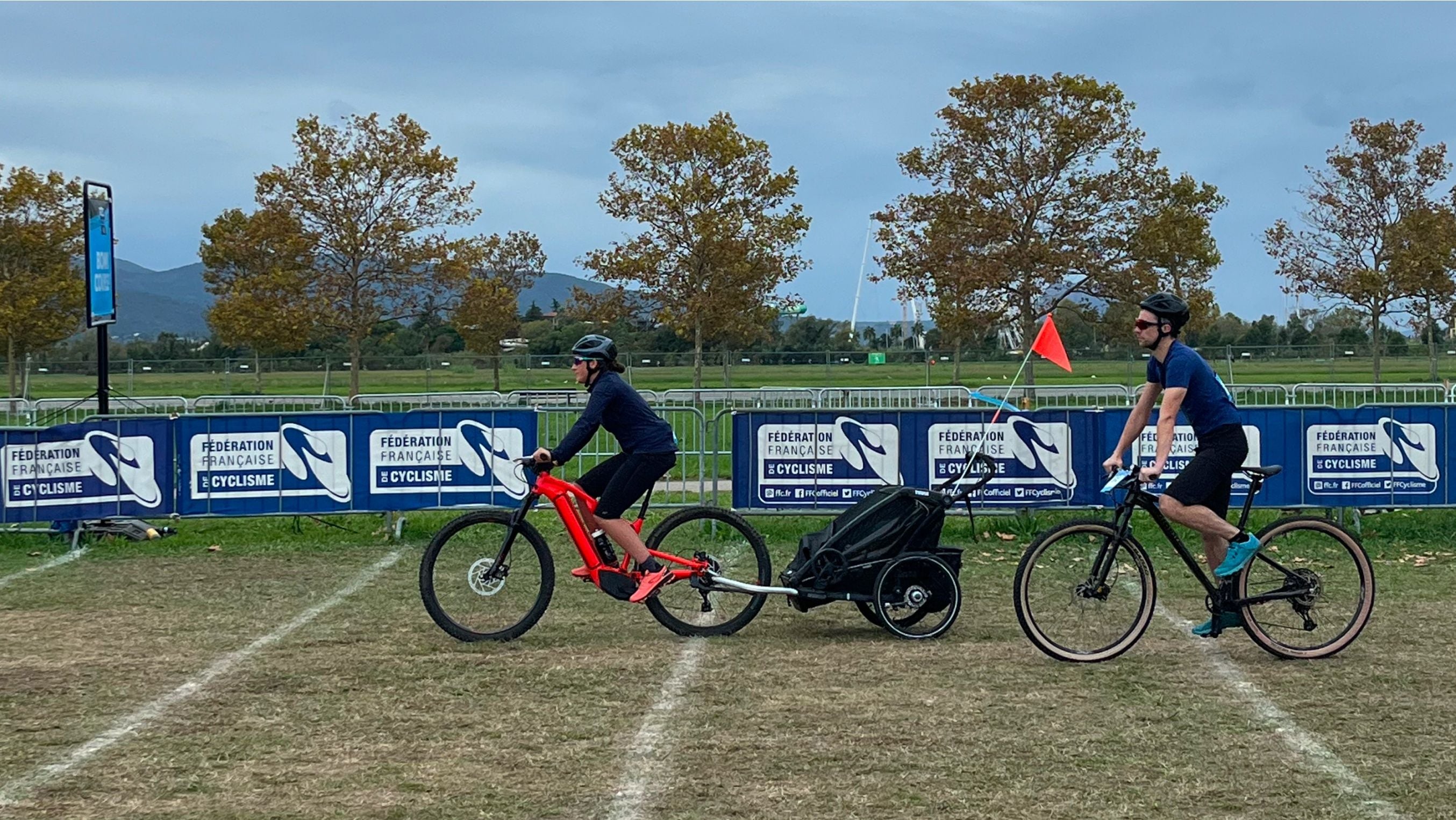 Kaksi pyöräilijää, joista toisen pyörään on kiinnitetty Thule Chariot -pyöräilyvaunu, ajaa Roc d’Azur -pyöräilykilpailuissa Etelä-Ranskassa.