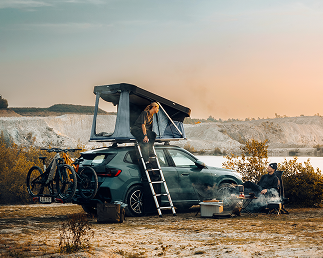 Tenda sul tetto di Thule montata vicino all'acqua al tramonto