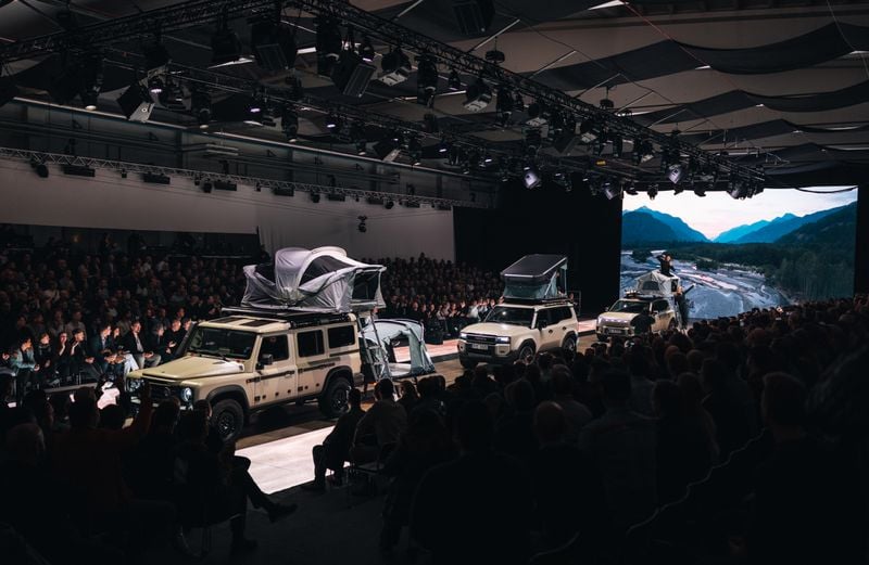 A car-catwalk with differemt greem cars, loaded with Thule gear