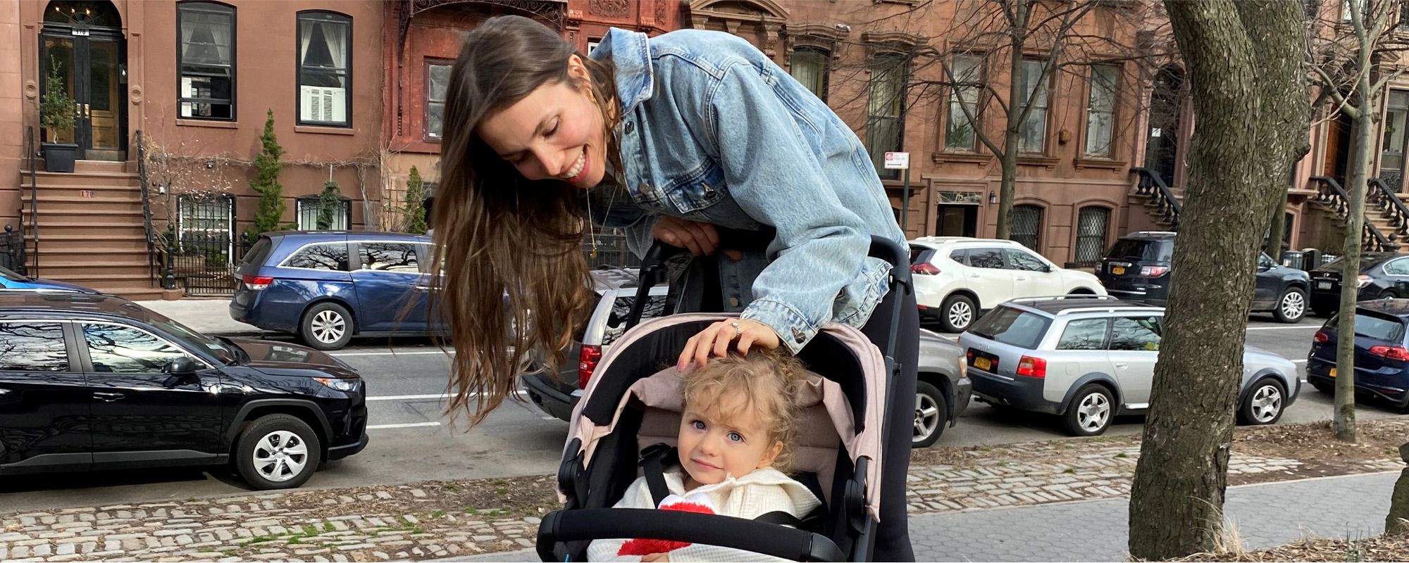 Olesia Anisimovich standing with her daughter in a Thule Spring stroller.