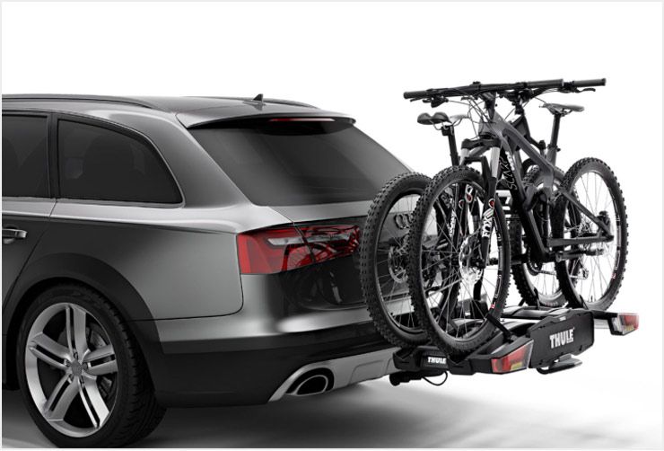 A car with a Thule towbar bike rack installed and two bikes loaded.