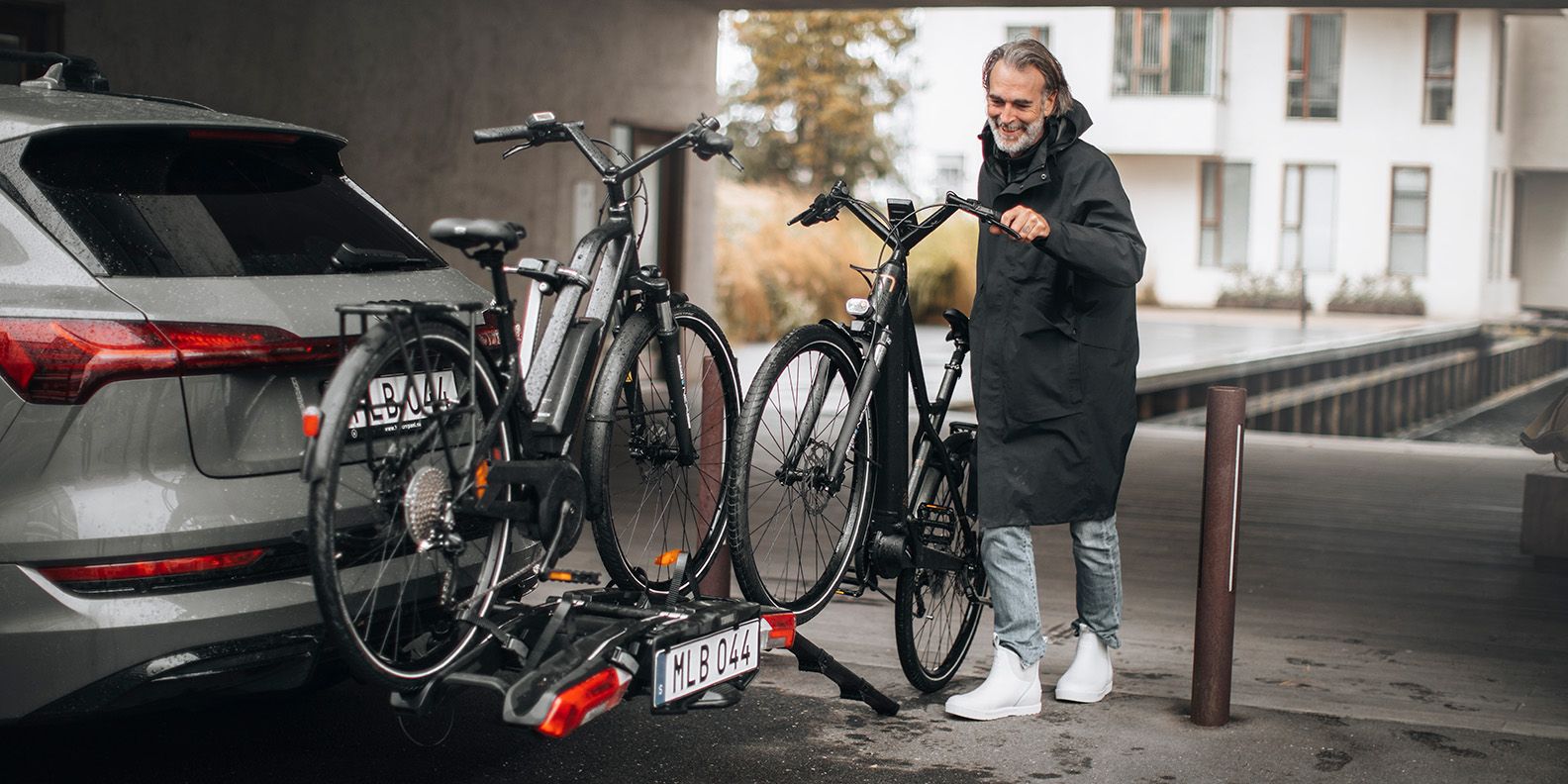 A man uses the Thule Epos Foldable Loading Ramp (sold separately) to mount a heavy e-bike onto the Thule Epos bike rack