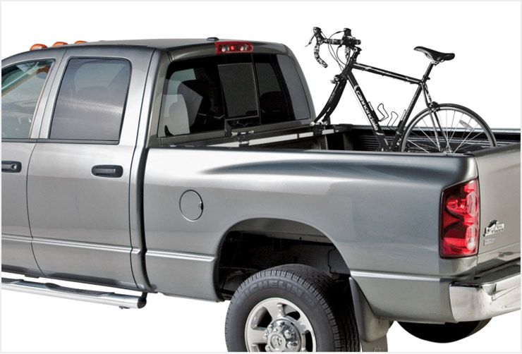 A pickup with a Thule truck bed bike rack installed and one bike loaded.