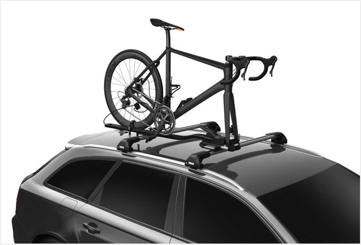 A car with a Thule roof bike rack installed and one bike loaded.