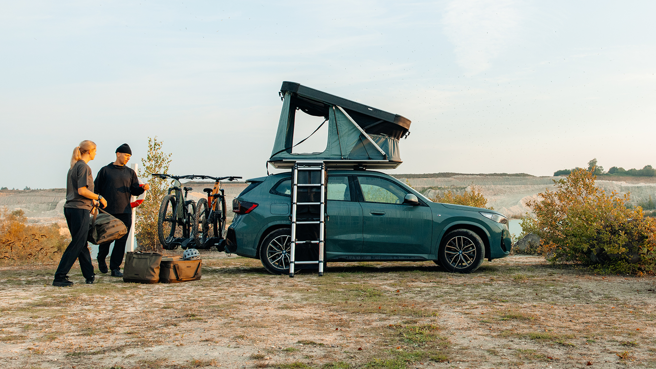 Tenda no telhado Thule montada em um carro à beira da costa