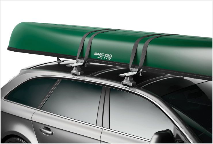 A zoomed in picture of a Thule Portage canoe rack mounted on the roof of a car.