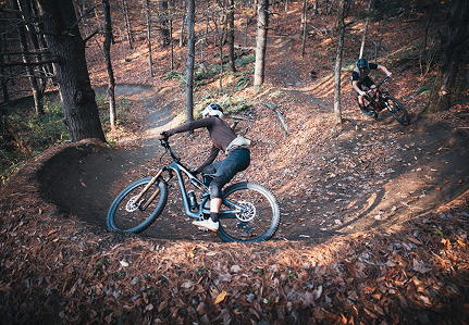 Žena projíždí zatáčkou na sjezdové cyklostezce. 