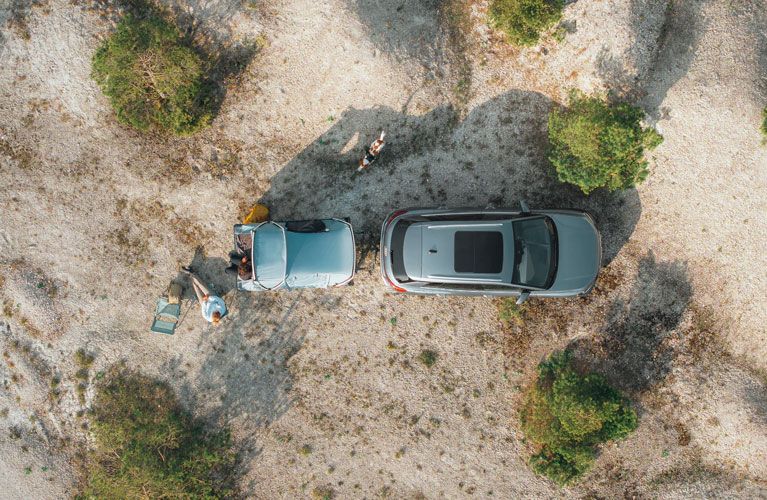A bird’s eye view of the Thule Outset tent attached to a car parked in the countryside.
