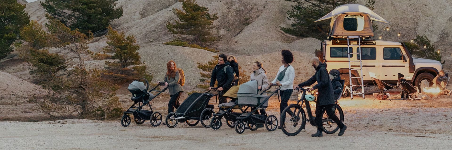幾個人推著 Thule 嬰兒車一起在戶外環境中行走。