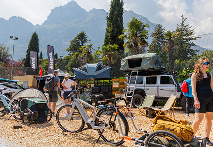 Les gens discutent dehors, à côté d’un installation de produits extérieurs Thule.