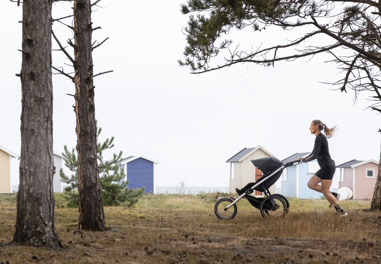 Femme faisant du jogging avec un enfant installé dans une poussette Thule Glide 3.