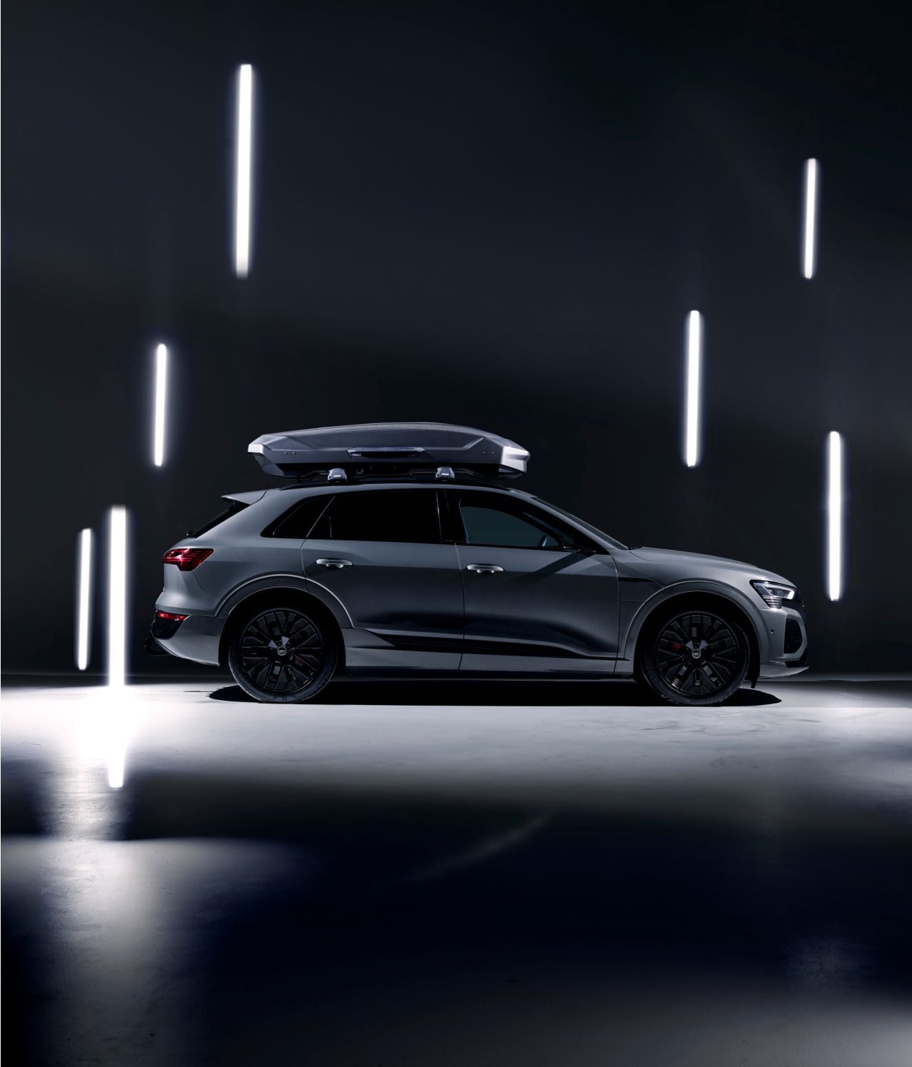 En bil utstyrt med en grå Thule Motion 3-takboks.