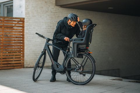 Osoba koja vozi teretni bicikl s dva Thule Yepp Nexxt 2 maxi dječja biciklistička sjedala.